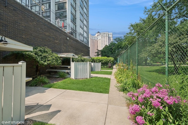 view of home's community with a yard and fence