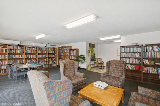 sitting room featuring carpet, bookshelves, and a wall unit AC