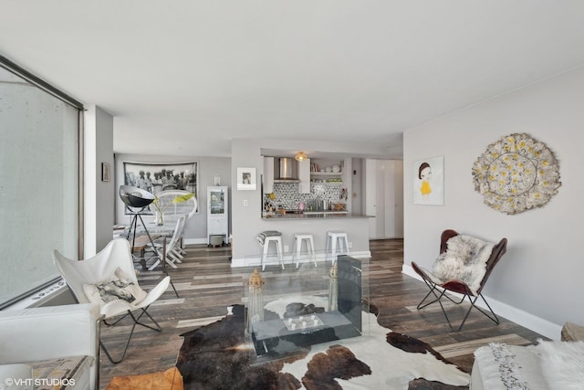 living room featuring a bar, wood finished floors, and baseboards