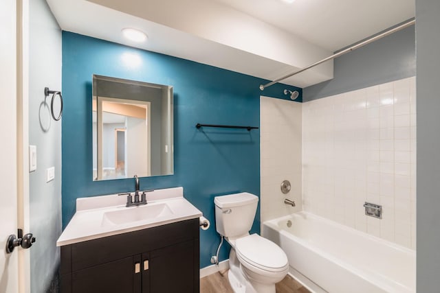 full bathroom with baseboards, toilet, wood finished floors, vanity, and washtub / shower combination