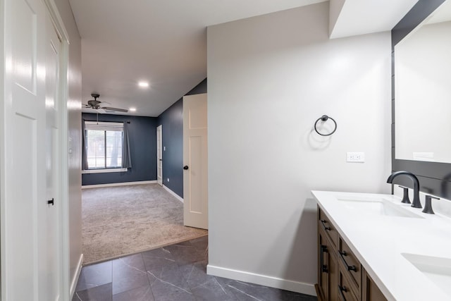 bathroom featuring double vanity, baseboards, ceiling fan, marble finish floor, and a sink