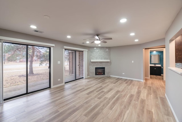 unfurnished living room featuring recessed lighting, a fireplace, light wood-style flooring, and baseboards