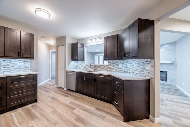 kitchen featuring a sink, dark brown cabinets, stainless steel dishwasher, and light countertops