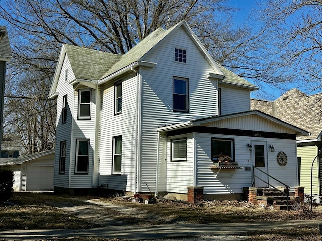 view of front of property featuring entry steps, roof with shingles, and an outdoor structure