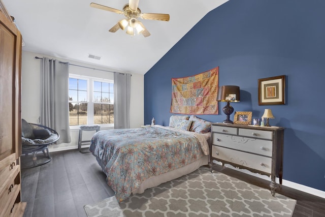 bedroom with lofted ceiling, visible vents, baseboards, and wood finished floors