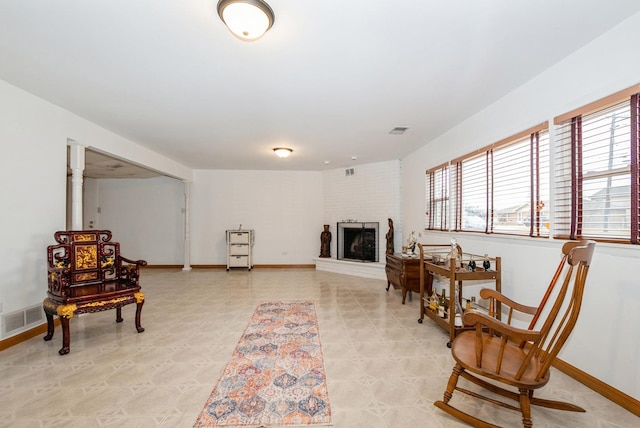 sitting room featuring a fireplace, visible vents, and baseboards