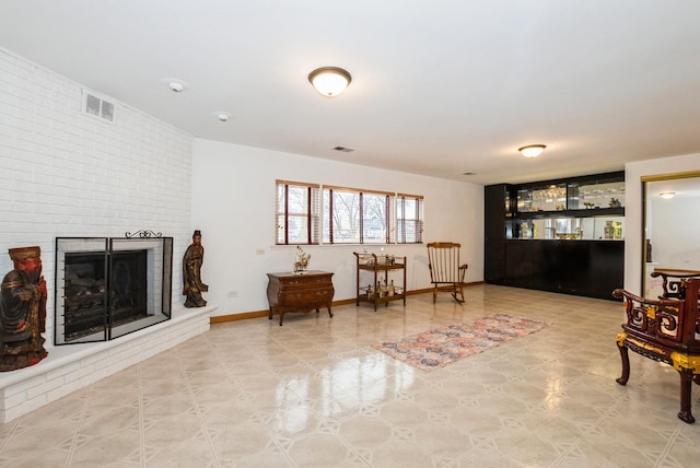 living area featuring a fireplace, visible vents, and baseboards