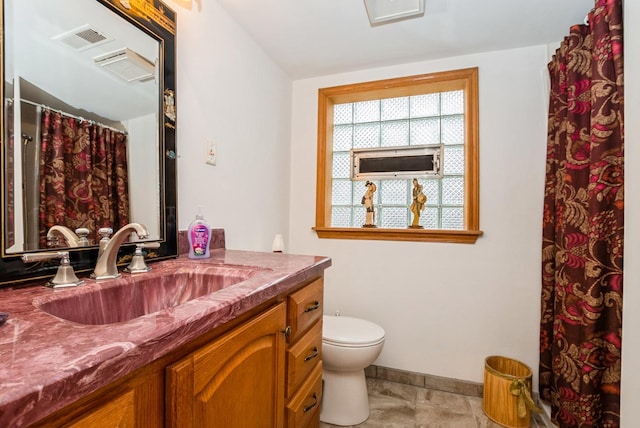 bathroom featuring visible vents, toilet, vanity, baseboards, and tile patterned floors