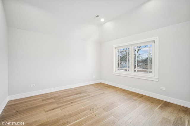 empty room with light wood finished floors, recessed lighting, visible vents, vaulted ceiling, and baseboards