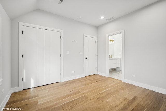 unfurnished bedroom featuring ensuite bathroom, recessed lighting, visible vents, baseboards, and light wood-style floors