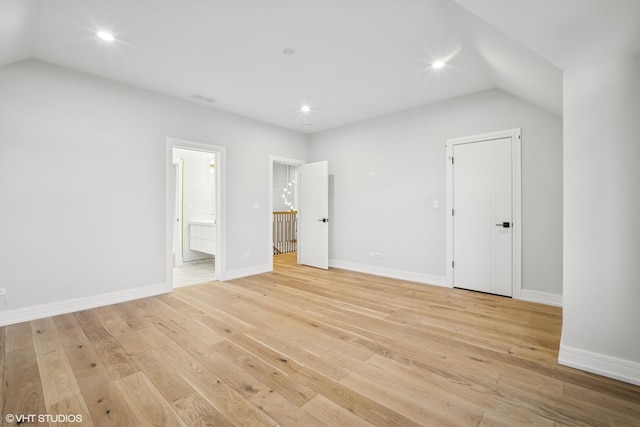 unfurnished bedroom featuring lofted ceiling, recessed lighting, baseboards, light wood-style floors, and ensuite bath