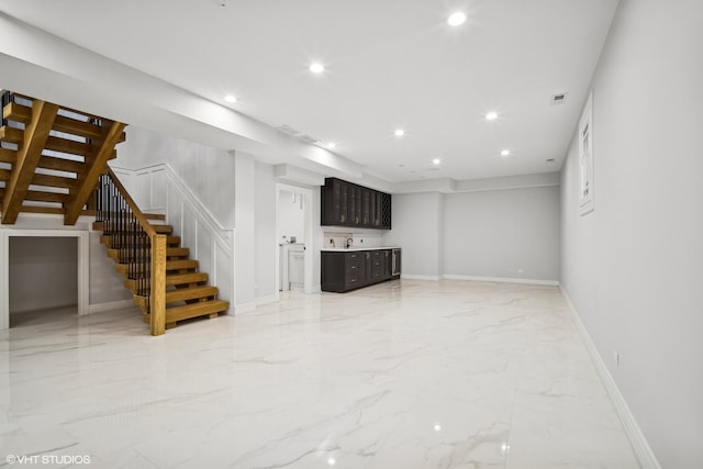 unfurnished living room featuring recessed lighting, baseboards, marble finish floor, stairway, and indoor wet bar