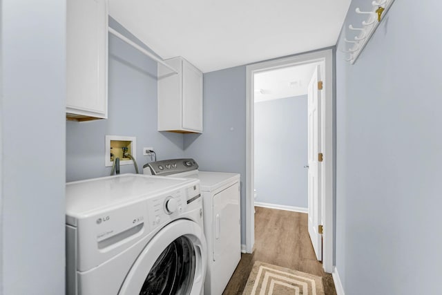 washroom featuring cabinet space, baseboards, washer and dryer, and wood finished floors