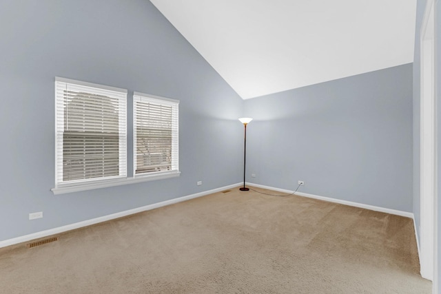 carpeted empty room with high vaulted ceiling, visible vents, and baseboards