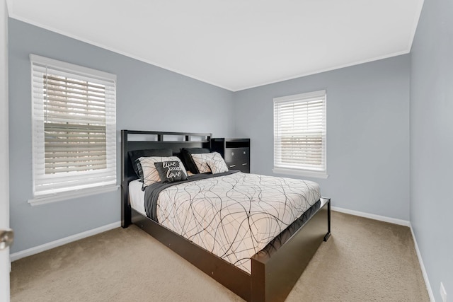 carpeted bedroom with crown molding and baseboards