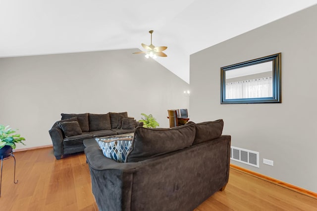 living area featuring lofted ceiling, visible vents, a ceiling fan, light wood-type flooring, and baseboards