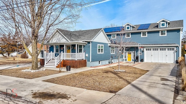 view of front of property with a garage, covered porch, driveway, and solar panels