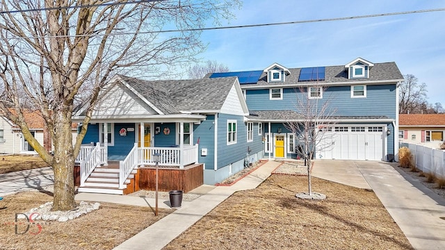 view of front of property with solar panels, covered porch, concrete driveway, fence, and a garage