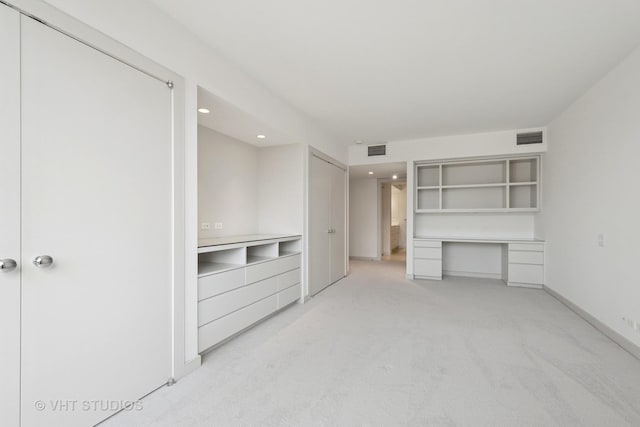 unfurnished living room featuring visible vents, light colored carpet, and baseboards