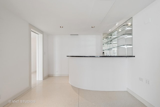 interior space with visible vents, baseboards, indoor bar, recessed lighting, and light speckled floor