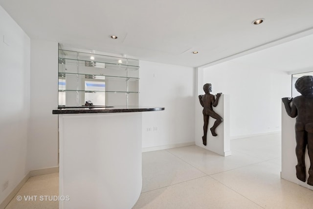 interior space featuring recessed lighting, speckled floor, and baseboards