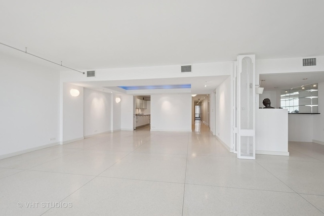 unfurnished room featuring visible vents and speckled floor