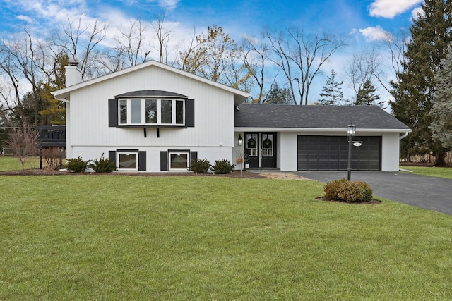 view of front of house featuring a garage, driveway, a chimney, and a front lawn