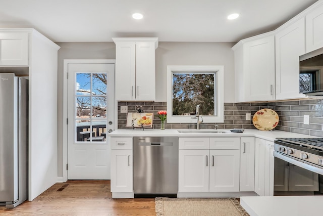 kitchen featuring a sink, white cabinetry, stainless steel appliances, and light countertops