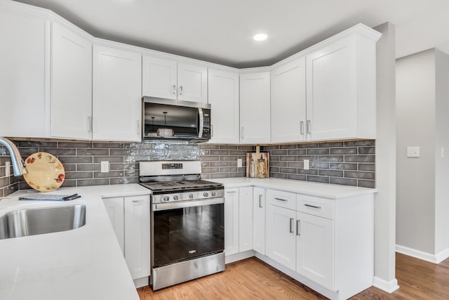 kitchen featuring stainless steel appliances, light countertops, and light wood-style floors