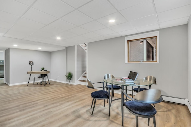 dining space featuring a paneled ceiling, recessed lighting, wood finished floors, baseboards, and stairs