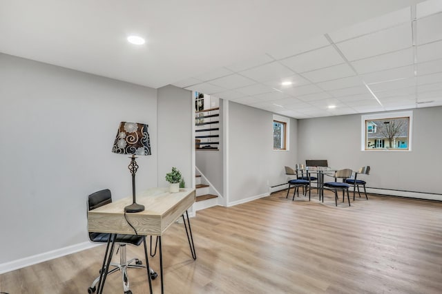 office with a healthy amount of sunlight, light wood-type flooring, a paneled ceiling, and baseboards