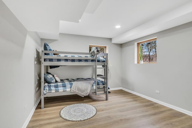 bedroom featuring baseboards, wood finished floors, and recessed lighting