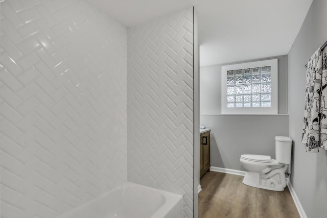 full bathroom with shower / bathing tub combination, toilet, vanity, wood finished floors, and baseboards