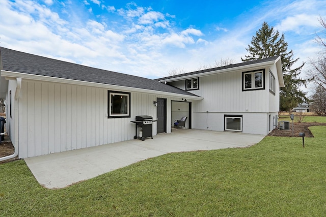 rear view of house with a yard, a shingled roof, a patio, and central air condition unit