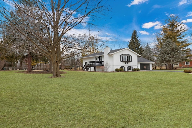 view of yard with driveway, an attached garage, and stairs