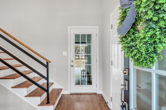 doorway featuring dark wood-style flooring, stairway, and baseboards