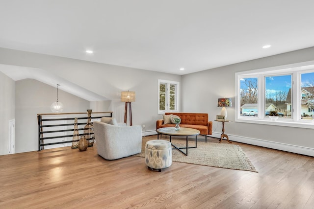 living area featuring a baseboard heating unit, recessed lighting, baseboards, and wood finished floors