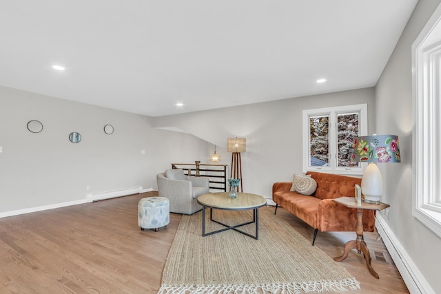 living area with baseboards, a baseboard radiator, a baseboard heating unit, and wood finished floors