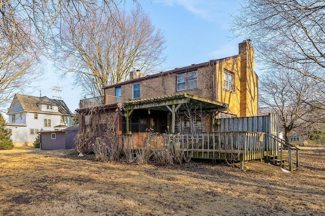 exterior space with brick siding, a chimney, and a wooden deck