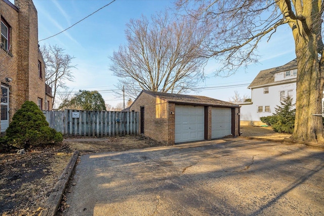 detached garage featuring fence