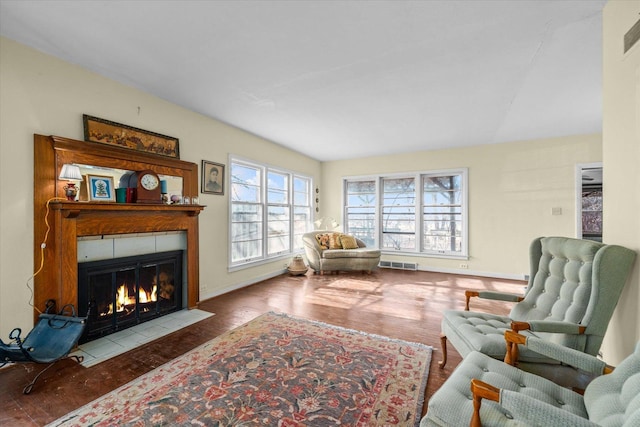 sitting room featuring baseboards, visible vents, wood finished floors, and a tile fireplace