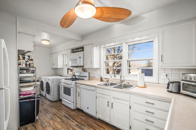 kitchen featuring white appliances, dark wood-style floors, washing machine and clothes dryer, a sink, and backsplash