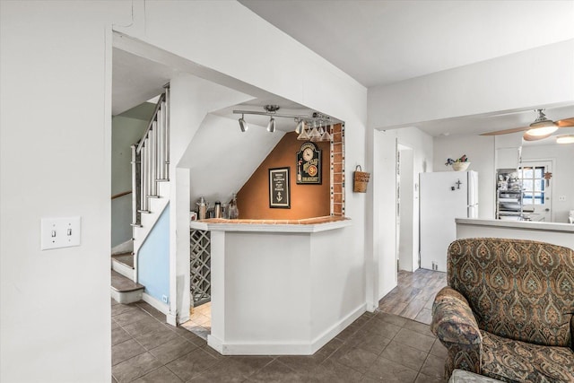 bar featuring baseboards, stairway, and freestanding refrigerator