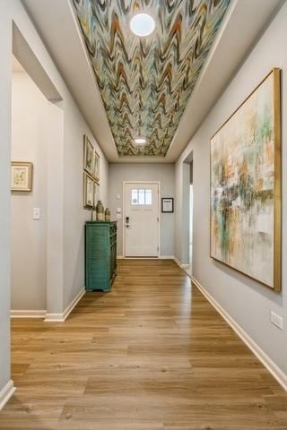 doorway with light wood-style floors and baseboards