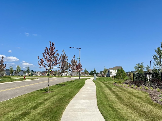 view of street featuring street lights, sidewalks, and a residential view