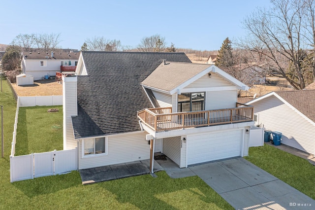 view of front facade with concrete driveway, a shingled roof, a front yard, and fence