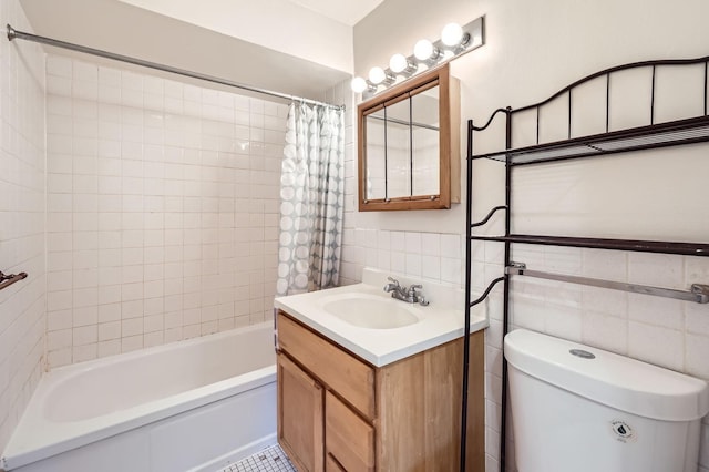 full bath featuring toilet, a wainscoted wall, shower / tub combo, vanity, and tile walls