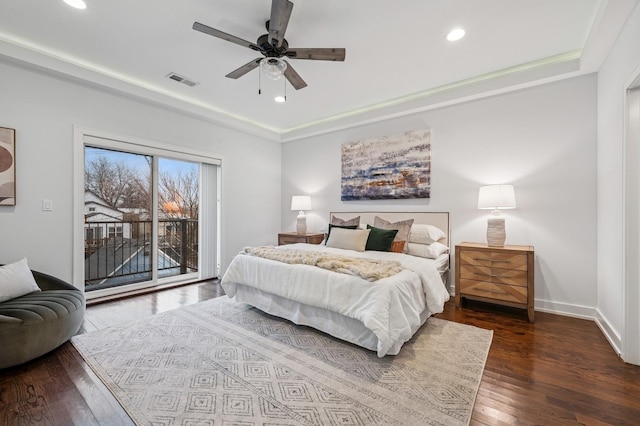 bedroom featuring recessed lighting, wood finished floors, visible vents, access to exterior, and a tray ceiling