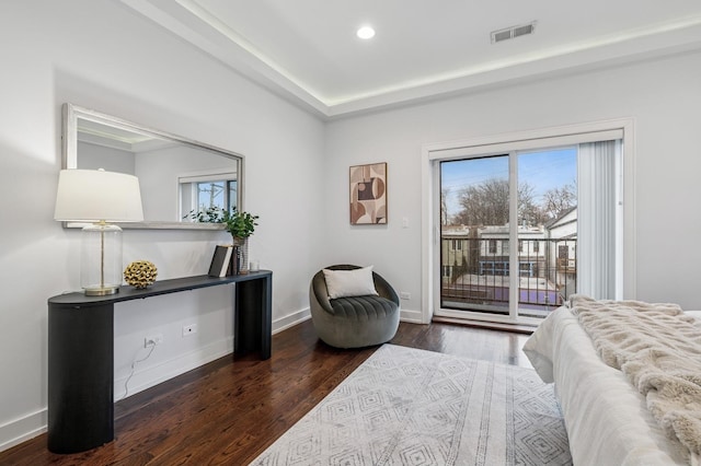 bedroom featuring access to exterior, baseboards, visible vents, and wood finished floors