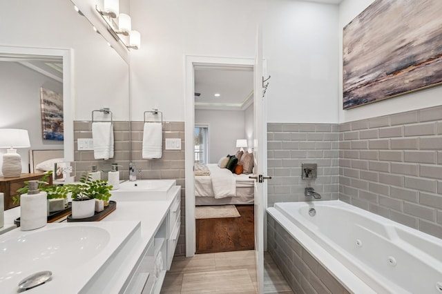 bathroom featuring a whirlpool tub, double vanity, a sink, and ensuite bathroom